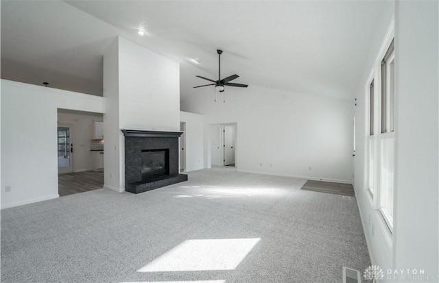 unfurnished living room with visible vents, high vaulted ceiling, a ceiling fan, carpet floors, and a brick fireplace