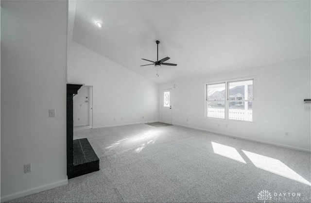 unfurnished living room with high vaulted ceiling, carpet flooring, baseboards, and ceiling fan