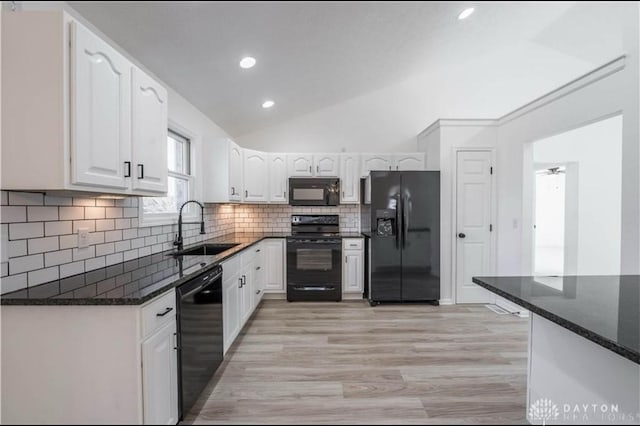 kitchen featuring backsplash, white cabinets, black appliances, and a sink