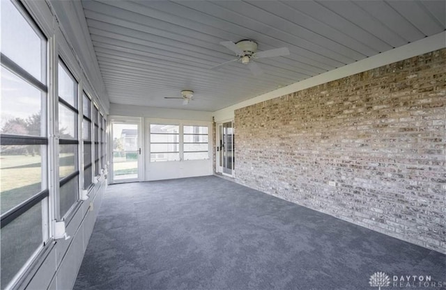 unfurnished sunroom featuring a ceiling fan