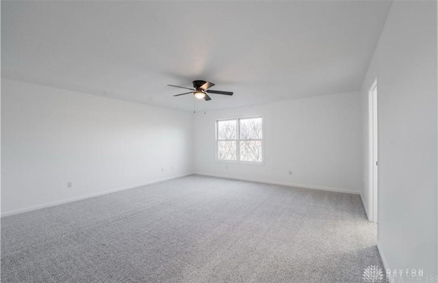 empty room featuring light carpet, baseboards, and ceiling fan