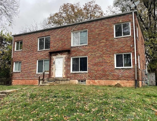 view of front of home with a front lawn and brick siding