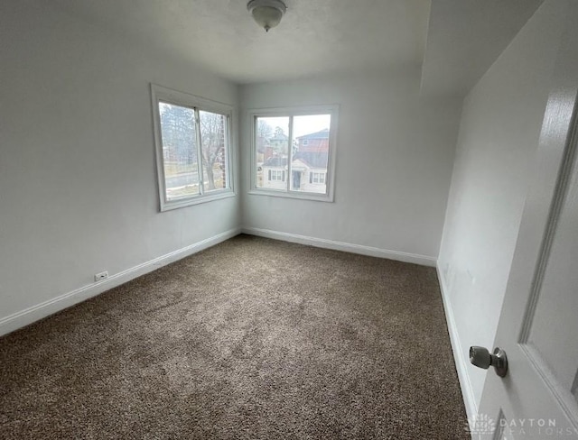 carpeted spare room featuring baseboards