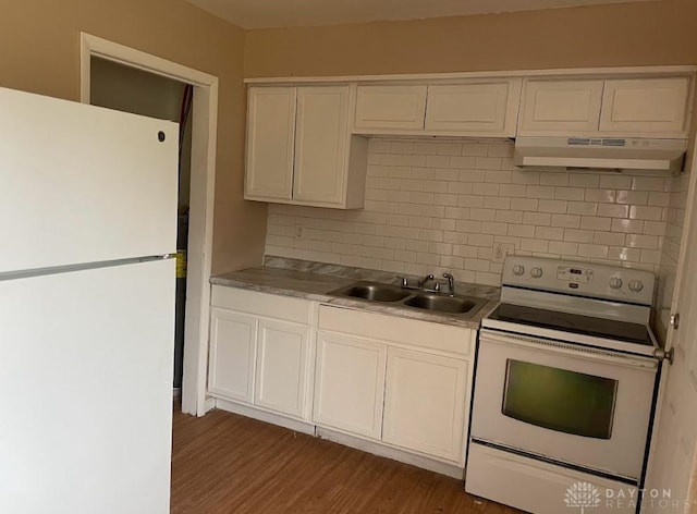 kitchen featuring tasteful backsplash, dark wood-type flooring, a sink, white appliances, and under cabinet range hood