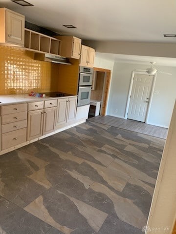 kitchen with double oven, black electric cooktop, under cabinet range hood, visible vents, and backsplash