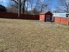 view of yard with a shed, fence, and an outbuilding