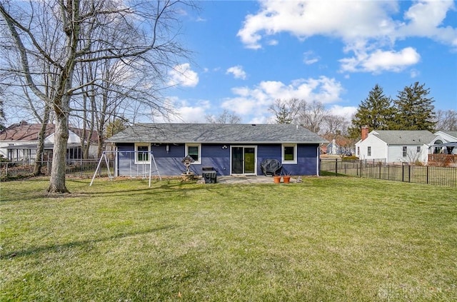 back of house with a yard and a fenced backyard