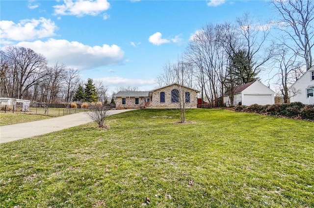 single story home featuring a garage, a front yard, fence, and an outbuilding