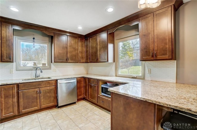 kitchen featuring light stone counters, light tile patterned floors, decorative backsplash, a sink, and dishwasher