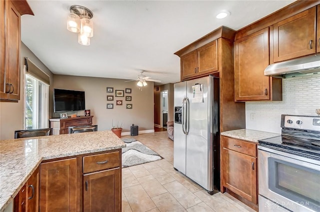 kitchen with ceiling fan, under cabinet range hood, appliances with stainless steel finishes, backsplash, and brown cabinetry