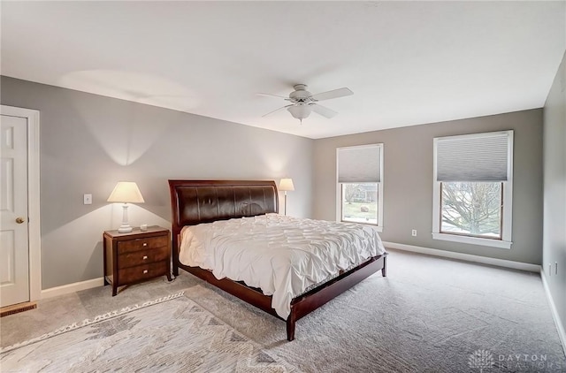 carpeted bedroom featuring a ceiling fan, visible vents, and baseboards