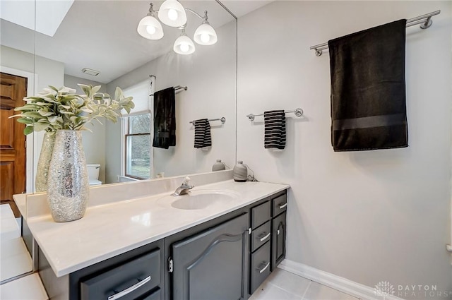 bathroom featuring toilet, tile patterned floors, vanity, and baseboards