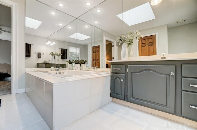 full bath featuring a skylight, tile patterned flooring, vanity, and recessed lighting