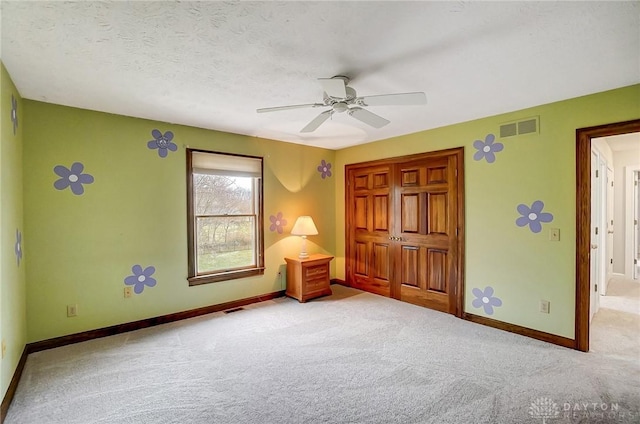 unfurnished bedroom featuring carpet floors, visible vents, and baseboards