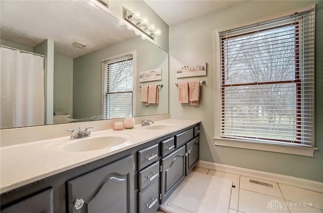 bathroom featuring double vanity, tile patterned flooring, a sink, and visible vents