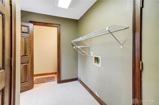 clothes washing area with laundry area, hookup for a washing machine, baseboards, and light tile patterned floors