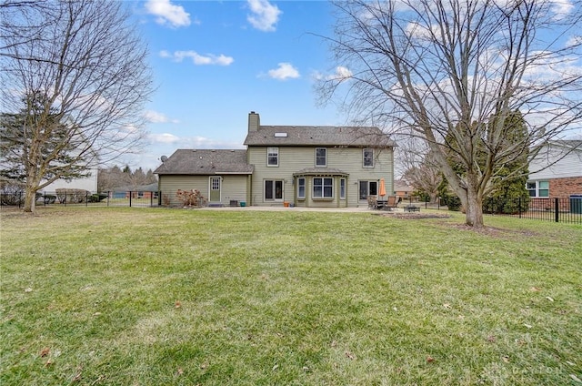 back of house with a fenced backyard, a patio, a chimney, and a lawn