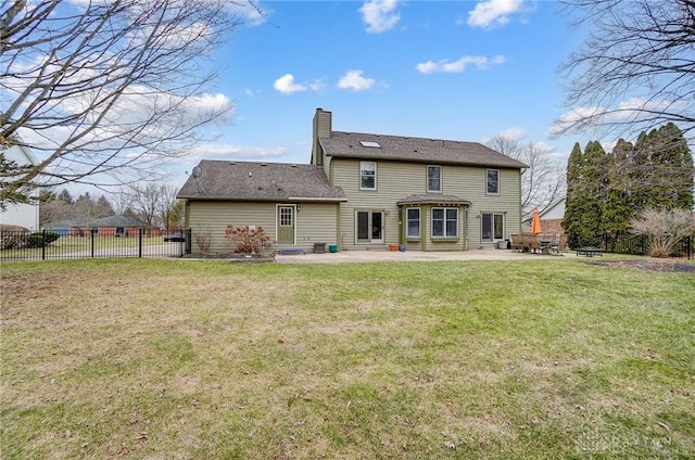 back of house with entry steps, a chimney, fence, a yard, and a patio area