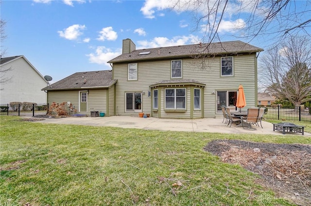 back of property with a patio area, a lawn, and fence