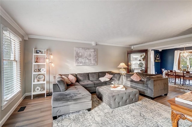 living room featuring visible vents, crown molding, baseboards, and wood finished floors