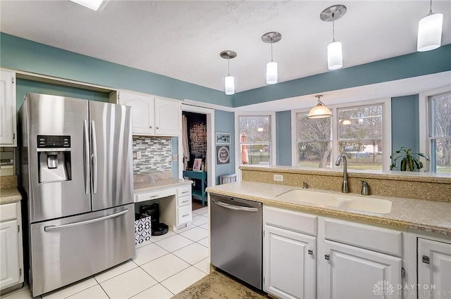 kitchen featuring backsplash, appliances with stainless steel finishes, white cabinets, and a sink