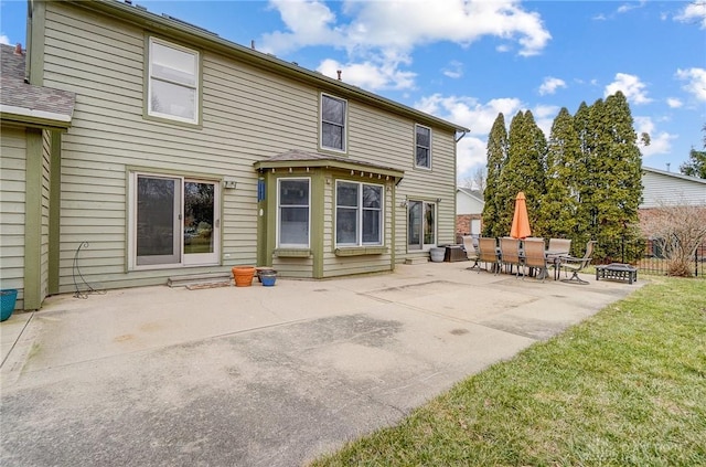 back of property with a patio, a lawn, and fence