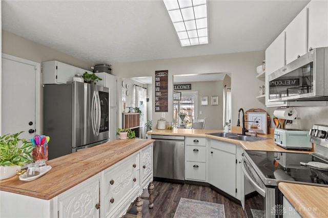 kitchen with white cabinetry, appliances with stainless steel finishes, dark wood-type flooring, and a sink