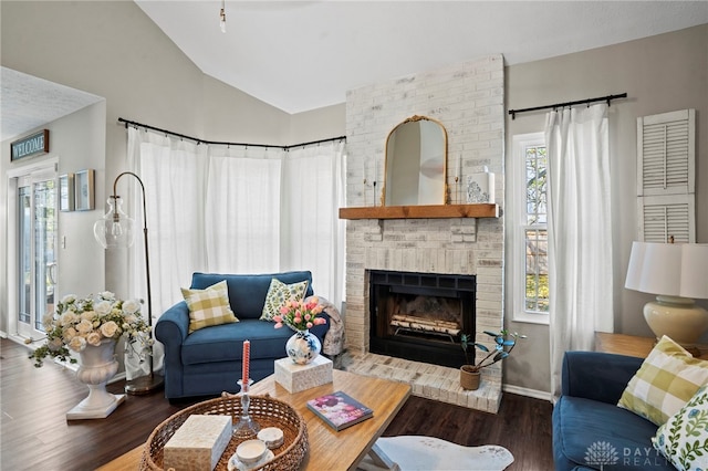 living area featuring a fireplace, vaulted ceiling, and wood finished floors