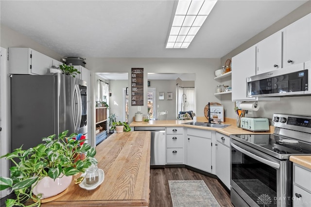 kitchen featuring white cabinetry, appliances with stainless steel finishes, and dark wood finished floors