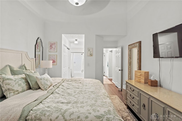 bedroom with dark wood-style flooring and ensuite bathroom