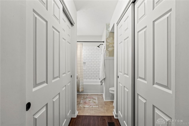 hall featuring dark wood-type flooring and visible vents