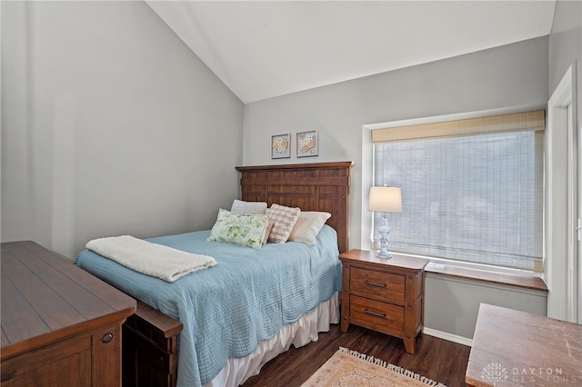 bedroom featuring lofted ceiling, multiple windows, baseboards, and dark wood finished floors