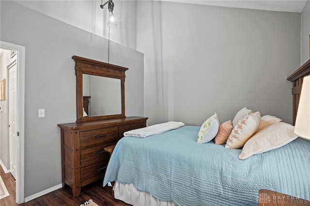 bedroom featuring dark wood-style floors and baseboards