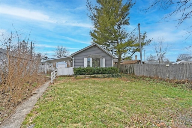 view of front facade with a carport, a front yard, and a fenced backyard