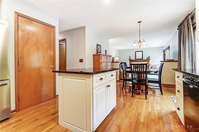 kitchen with light wood finished floors, white cabinets, dishwasher, freestanding refrigerator, and pendant lighting