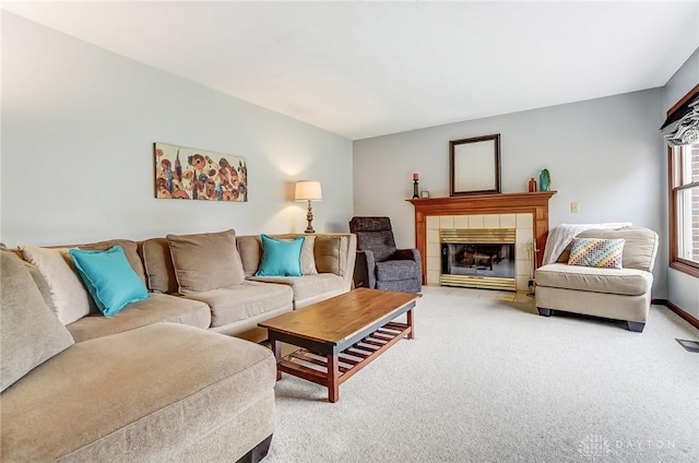 living area featuring a tile fireplace, light carpet, visible vents, and baseboards