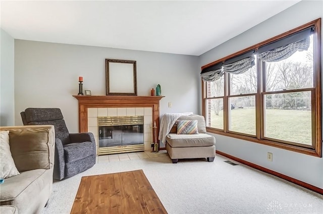 sitting room featuring carpet, a tiled fireplace, visible vents, and baseboards