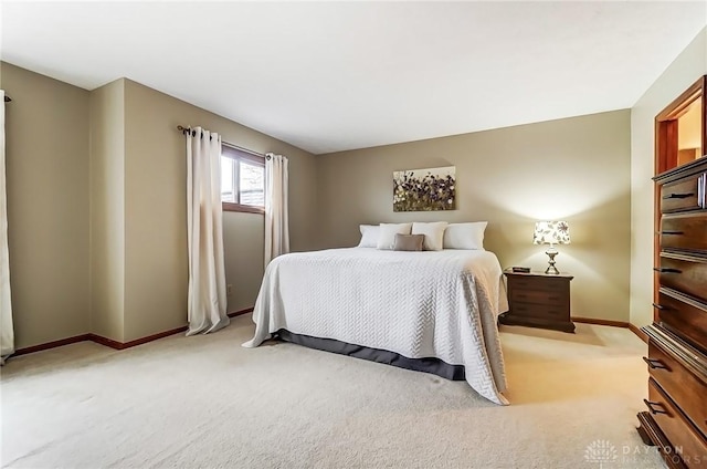 bedroom with light colored carpet and baseboards