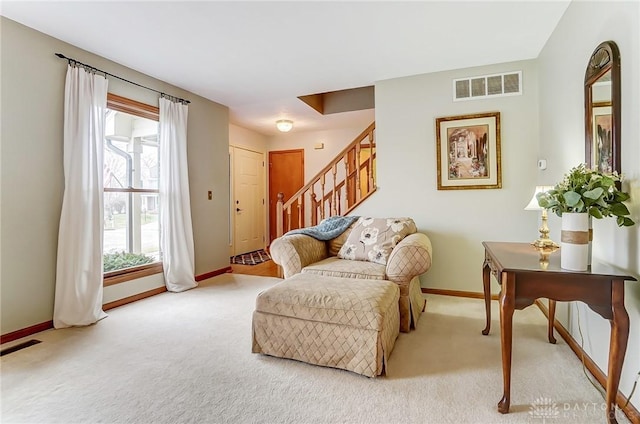 living area featuring carpet floors, stairway, visible vents, and baseboards