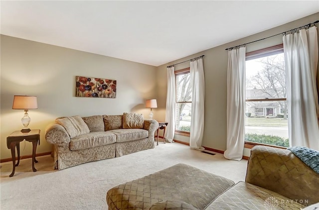 living room featuring light carpet, visible vents, and baseboards