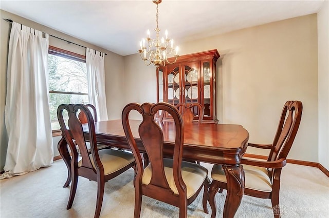 carpeted dining room featuring baseboards and a notable chandelier