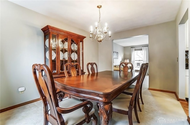 dining room with a chandelier and baseboards