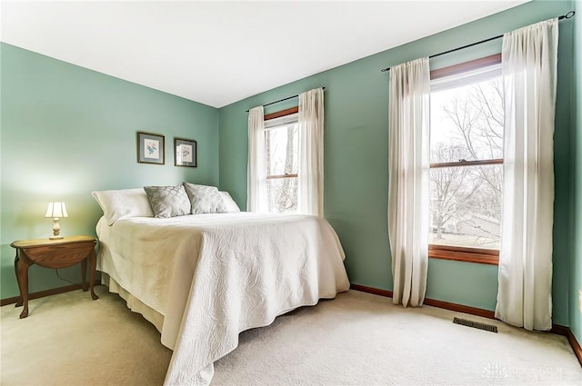 carpeted bedroom featuring visible vents and baseboards