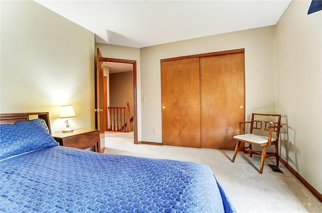 carpeted bedroom with a closet and baseboards