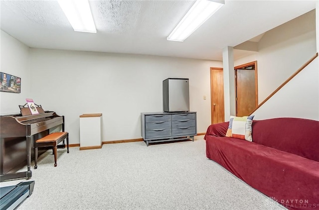 carpeted living room featuring baseboards and a textured ceiling