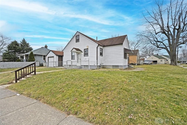 bungalow-style home featuring a detached garage, fence, a front lawn, and an outbuilding