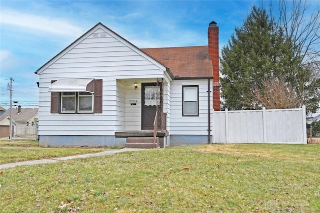 bungalow-style house featuring a shingled roof, a front yard, fence, and a chimney