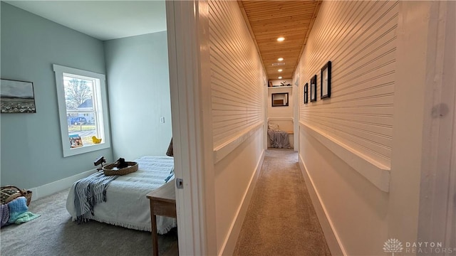 hall featuring recessed lighting, carpet, wood ceiling, and baseboards