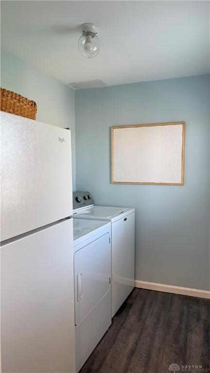 washroom featuring baseboards, laundry area, washer and clothes dryer, and dark wood-style flooring