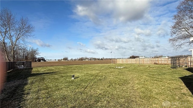 view of yard with fence and a rural view